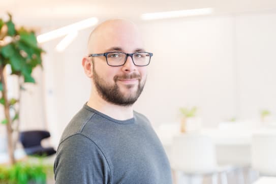 Shopware Mitarbeiter lächelt in die Kamera.